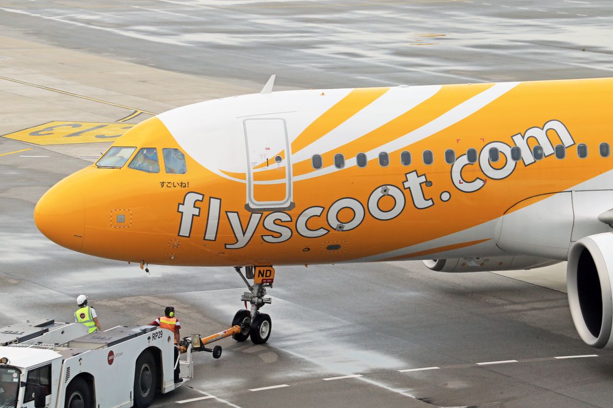Airliner being towed by a pushback tug on the apron